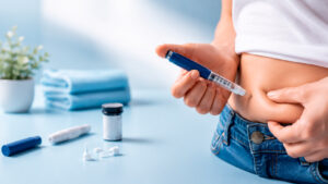 Persona administrándose una inyección de insulina en el abdomen para ilustrar un artículo sobre la prevención de la lipohipertrofia en personas con diabetes.